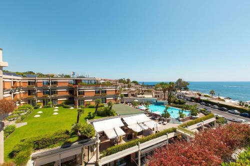 une vue aérienne d'un complexe hôtelier avec piscine et l'océan dans l'établissement Four Points by Sheraton Catania Hotel, à Catane