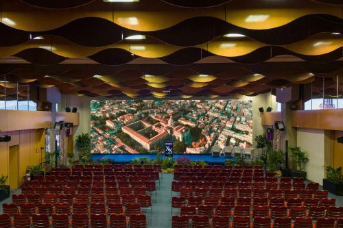 an empty hall with red chairs and a large screen at Four Points by Sheraton Catania Hotel in Catania