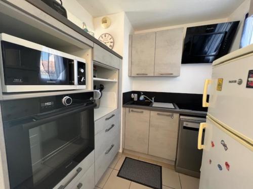 La cuisine est équipée d'un four noir et d'un four micro-ondes. dans l'établissement Maison lumineuse au calme, pres mer, au Château-dʼOléron