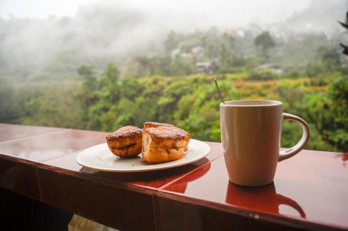 a plate of muffins next to a cup of coffee at Rice Homestay in Banaue