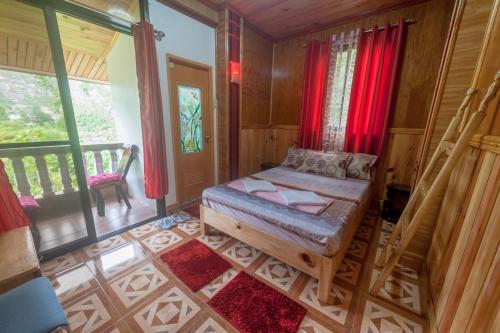 Habitación pequeña con cama y balcón. en Rice Homestay, en Banaue