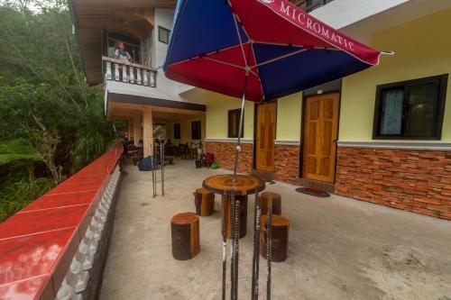 a patio with a table and an umbrella at Rice Homestay in Banaue