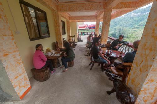 un grupo de personas sentadas en mesas en un restaurante en Rice Homestay, en Banaue