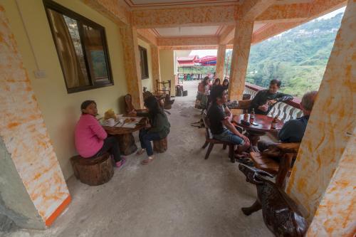 un grupo de personas sentadas en mesas en un restaurante en Rice Homestay en Banaue