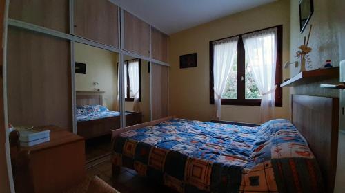 une chambre avec un lit et un miroir dans l'établissement Maison à 8min de plage Giraudière, à Grand-Village-Plage
