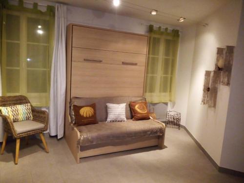 a room with a chair and a bench with pillows at Studio lumineux à 2 pas de la mer in Le Château-dʼOléron