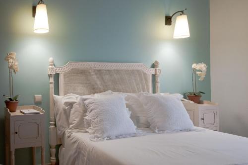 a white bed with white pillows and two night stands at Hotel Parque das Laranjeiras in Vilamoura