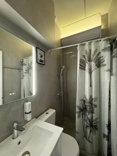 a bathroom with a sink and a shower curtain at Hermes Suite Klathmonos by Zeussuites in Athens