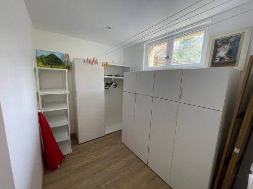 une cuisine avec des armoires blanches et une fenêtre dans l'établissement L'escapade, proche centre ville, à Quimper