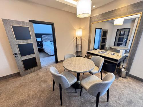 a room with a table and chairs and a bedroom at Doubletree By Hilton Kars Sarikamis in Sarıkamıs