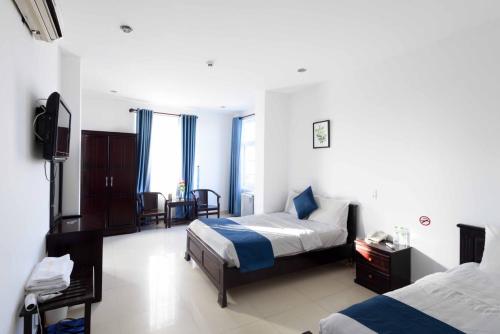 a hotel room with two beds and a television at Tehana Beach Hotel Da Nang in Da Nang