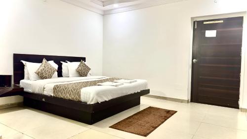 a bedroom with a large bed with a black door at Hotel Dev Palace in Ahmedabad