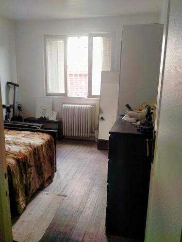 Cette chambre comprend un lit, une commode et un réfrigérateur. dans l'établissement Court séjour à Paris 2mn de métro, à Villejuif