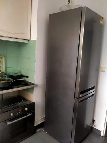 - un réfrigérateur en acier inoxydable dans la cuisine dans l'établissement Court séjour à Paris 2mn de métro, à Villejuif