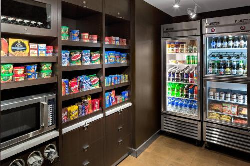 a kitchen with a refrigerator filled with lots of drinks at Courtyard by Marriott Pittsburgh Airport in Coraopolis