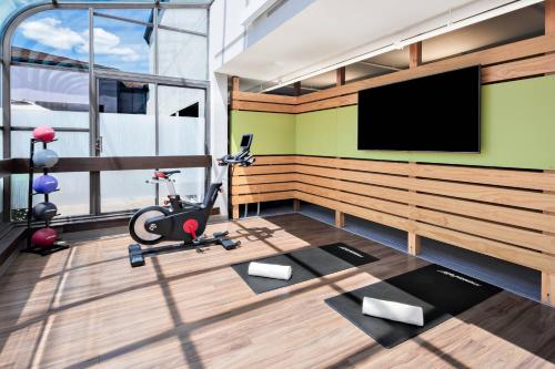 a room with a gym with a flat screen tv at Courtyard by Marriott Pittsburgh Airport in Coraopolis