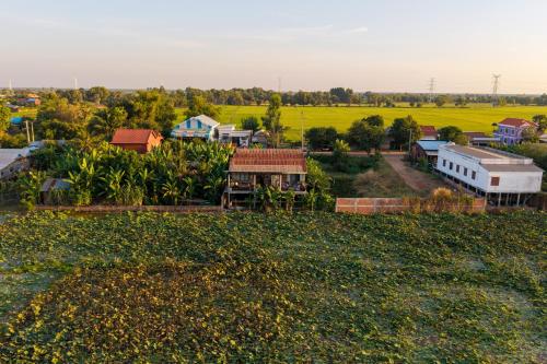 an aerial view of a small town with houses and a field at Pomelo Outpost Cambodia ដំណាក់ភ្នំក្រោម in Phumĭ Rœssei Lŭk