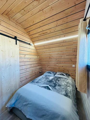 Cette chambre comprend un lit dans une cabane en bois. dans l'établissement Chalet cosy en Aubrac, à Nasbinals