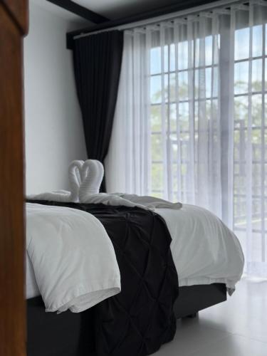 a bedroom with a bed with white pillows and a window at Las Villas De La Serenidad in Calatagan