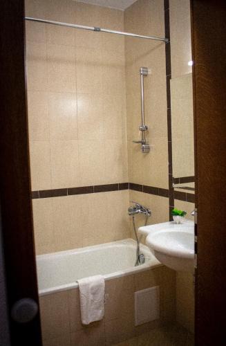 a bathroom with a bath tub and a sink at GO GO Holiday in Borovets
