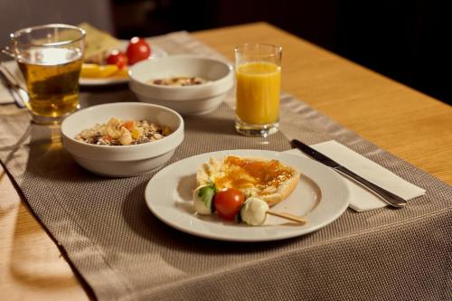 a table with plates of food and glasses of orange juice at Parkhotel Kirchberg in Kirchberg in Tirol