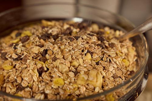 a bowl of granola with a spoon in it at Parkhotel Kirchberg in Kirchberg in Tirol