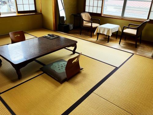 a living room with a coffee table and chairs at Chikurinin Gunpoen in Yoshino