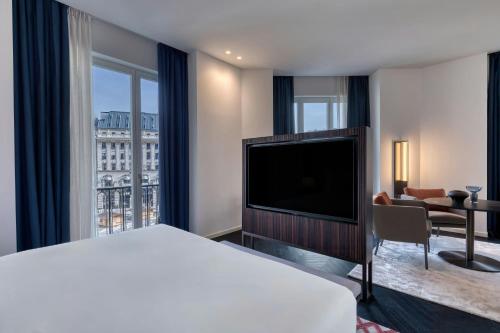 a hotel room with a bed and a flat screen tv at Dorothea Hotel, Budapest, Autograph Collection in Budapest