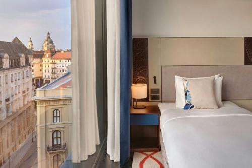 a bedroom with a bed and a view of a city at Dorothea Hotel, Budapest, Autograph Collection in Budapest