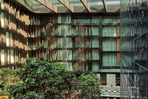 a glass building with trees in front of it at Dorothea Hotel, Budapest, Autograph Collection in Budapest