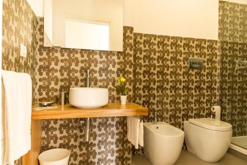 a bathroom with a sink and a toilet and a mirror at Stella Marina in Mazzeo