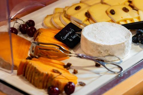 a tray of cheese and fruit on a plate at L'Hermitage Gantois, Autograph Collection in Lille