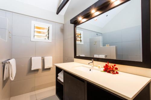 a bathroom with a sink and a large mirror at Plantation Island Resort in Malolo Lailai