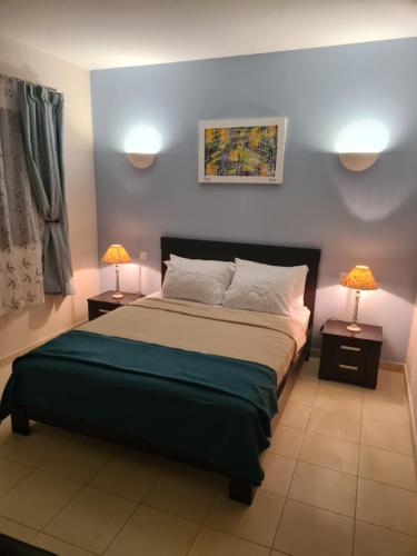 a bedroom with a bed and two lamps on tables at Unique Poolside Apartment in Santa Maria