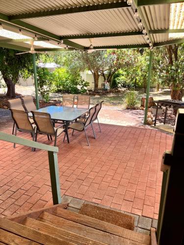 a patio with a table and chairs under a canopy at Begonia Cottage in Dwellingup