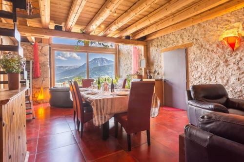 une salle à manger avec une table et une grande fenêtre dans l'établissement Les Esseroliettes NATURE & SPA, à Arith