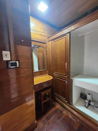 a small bathroom with wooden cabinets and a sink at Solstice Phuket in Nai Thon Beach