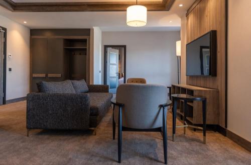 a living room with a couch and a chair at Doubletree By Hilton Kars Sarikamis in Sarıkamıs