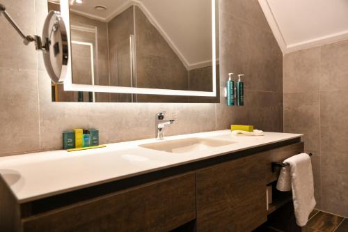 a bathroom with a sink and a mirror at Doubletree By Hilton Kars Sarikamis in Sarıkamıs