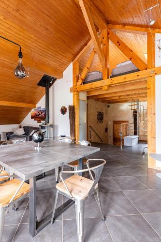 une salle à manger avec une grande table et des chaises dans l'établissement Grand appartement La Grangeat, à Magland