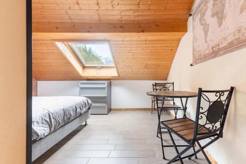 une chambre avec un lit, une table et une fenêtre dans l'établissement Grand appartement La Grangeat, à Magland