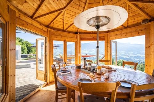 una sala da pranzo in legno con tavolo e sedie di Les Esseroliettes NATURE & SPA ad Arith
