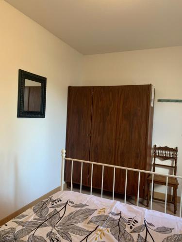 a bedroom with a bed and a wooden cabinet at gîtes "Entre les Vignes" in Tourreilles
