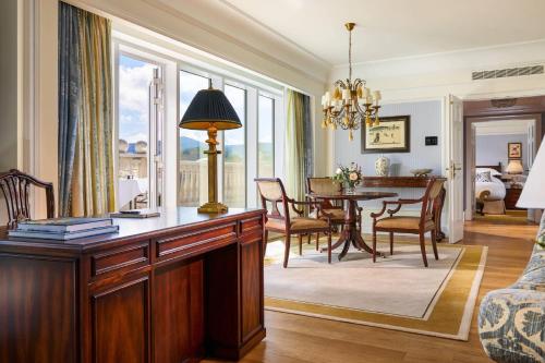 a living room with a table and a dining room at Powerscourt Hotel, Autograph Collection in Enniskerry