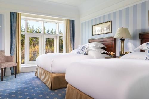 a hotel room with two beds and a window at Powerscourt Hotel, Autograph Collection in Enniskerry