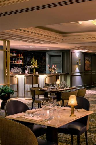 a restaurant with tables and chairs and a bar at Powerscourt Hotel, Autograph Collection in Enniskerry