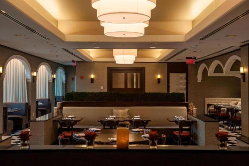 a restaurant with tables and chairs and a chandelier at Renaissance Providence Downtown Hotel in Providence