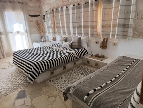 a bedroom with two beds and a window at Dar Ayed Tamezret in Tamezret