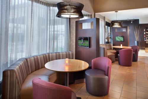 a waiting room with a couch and a table and chairs at Courtyard by Marriott Fayetteville in Fayetteville