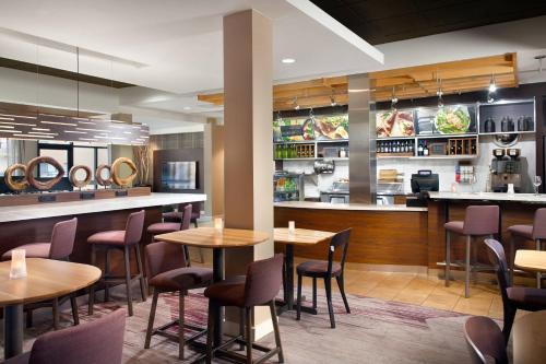 a restaurant with tables and chairs and a counter at Courtyard by Marriott Fayetteville in Fayetteville